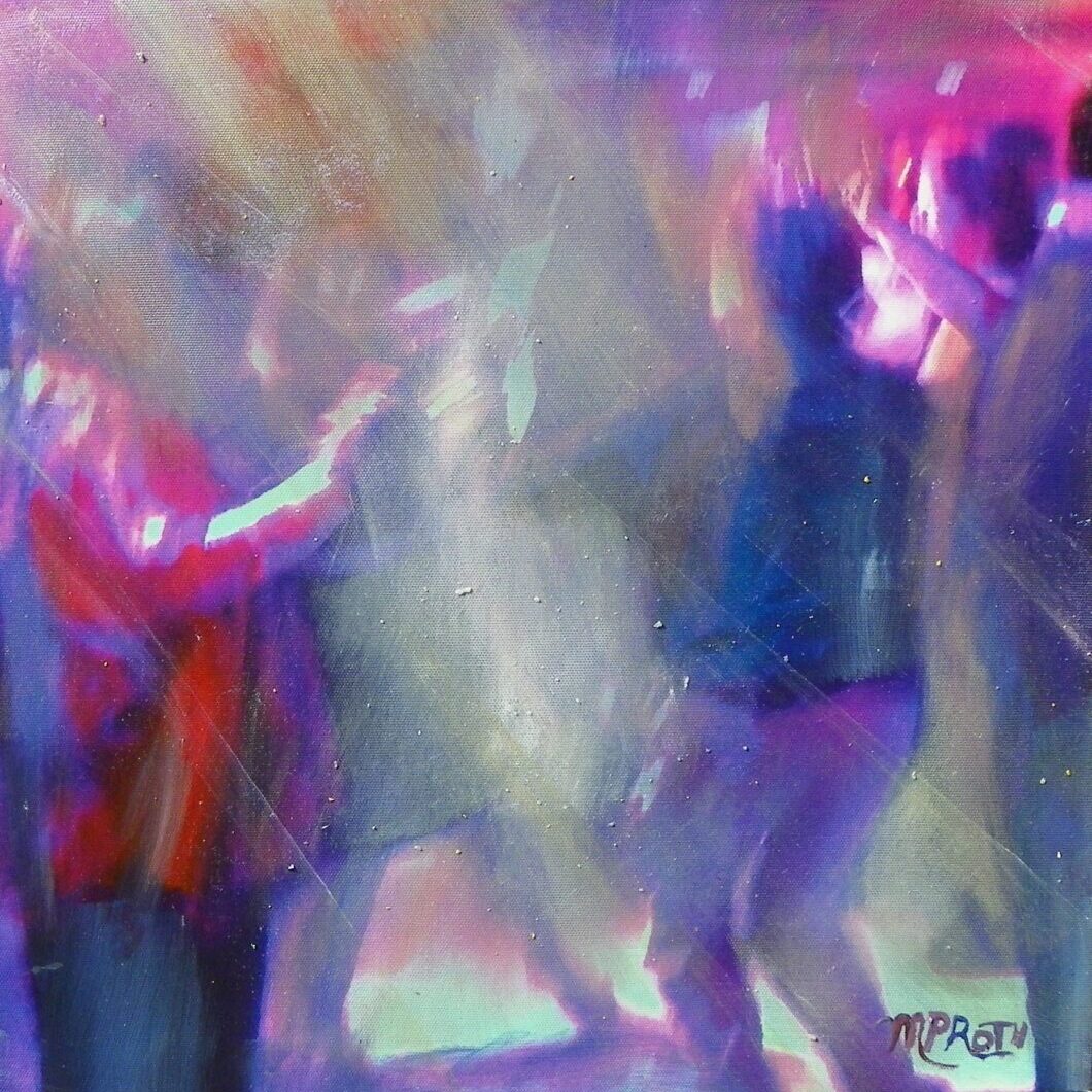 A blurry picture of people dancing in the night.