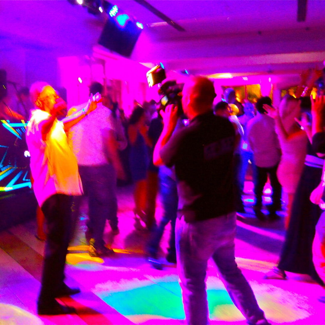 A group of people dancing in a room with lights.