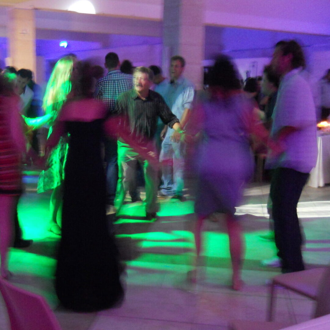 A group of people dancing in the middle of a room.